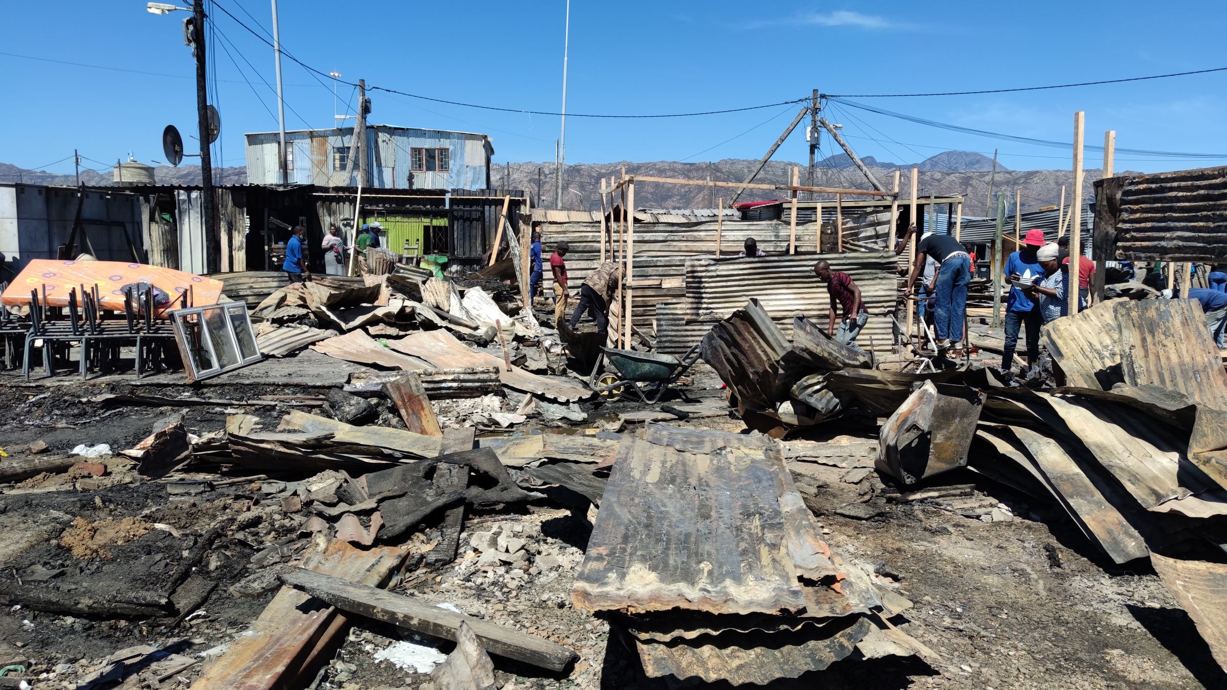 People cleaning up and rebuilding their houses after the fire in Nomzamo