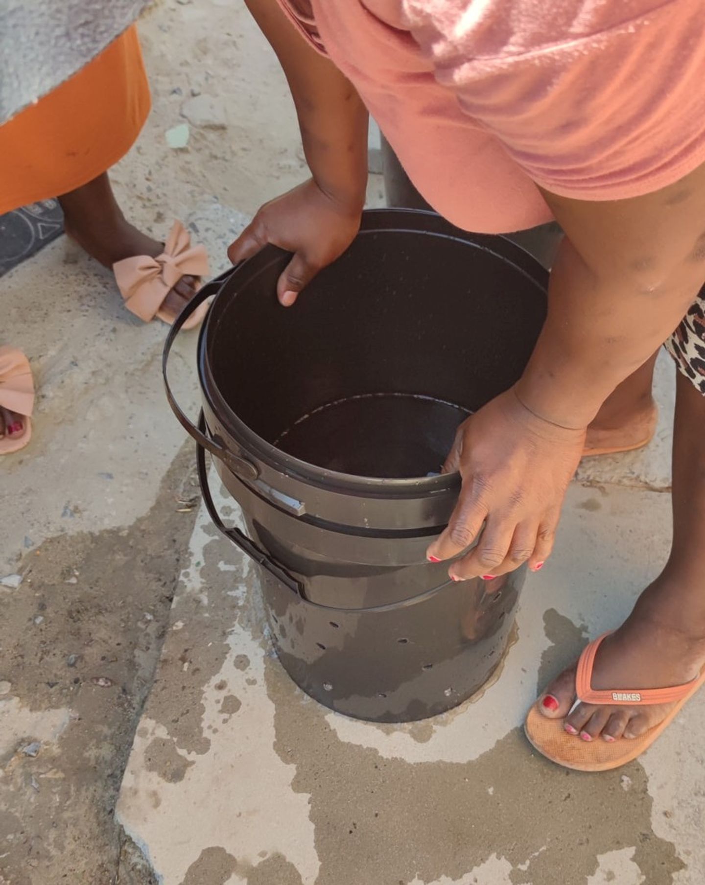 Pushing a bucket onto the laundry in the bucket with holes